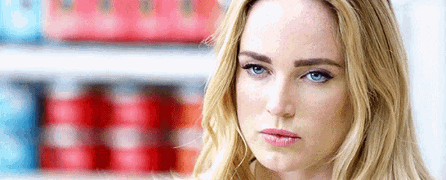 a close up of a woman 's face with blue eyes looking at the camera .