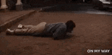 a man is laying on the ground next to a limousine .