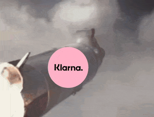 a pink circle with the word klarna written on it