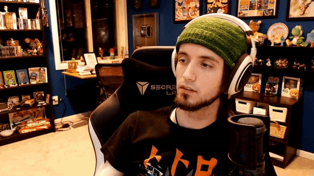 a man wearing headphones in a room with a secret lab logo on the wall