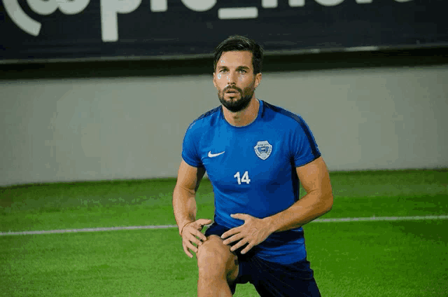 a man in a blue nike shirt with the number 14 on it