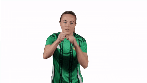 a woman in a green and black adidas shirt is boxing
