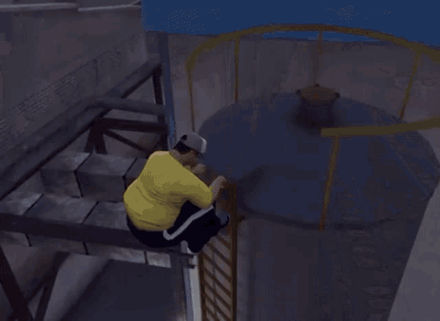 a man in a yellow shirt is climbing up a ladder .