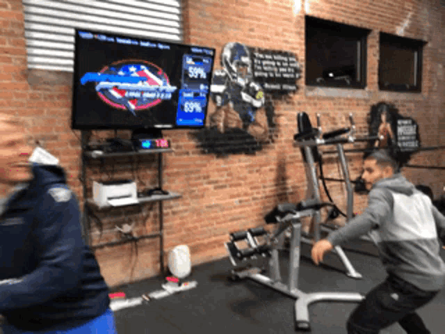 two men are playing a game in a gym with a screen displaying a score of 59