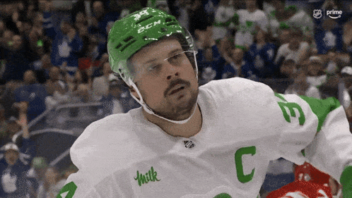a hockey player wearing a white jersey with the letter c on the sleeve
