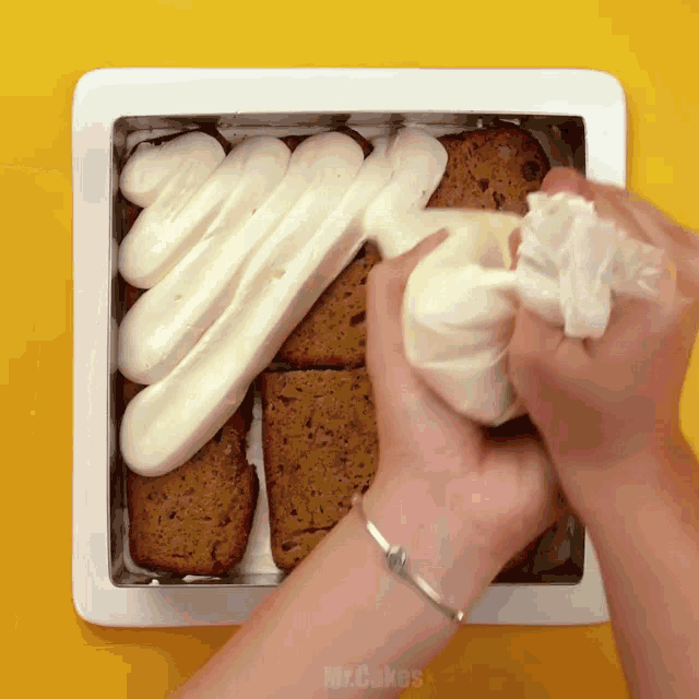 a person is frosting a cake in a box that says mr. cakes