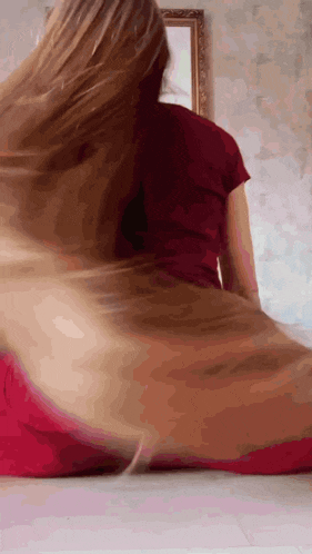 a woman with long hair is sitting on the floor