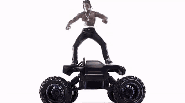 a man is standing next to a remote controlled monster truck .