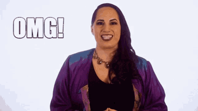 a woman in a purple jacket is making a funny face and saying `` omg '' .