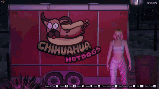 a woman stands in front of a chihuahua hotdog trailer