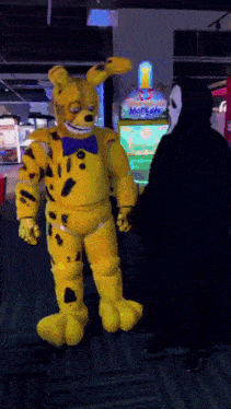 a person in a yellow bunny costume is standing next to a person in a black hoodie with a mask on .