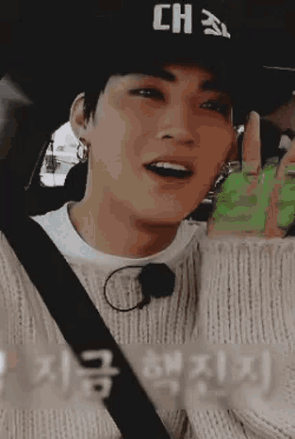 a close up of a person wearing a hat and a sweater in a car .