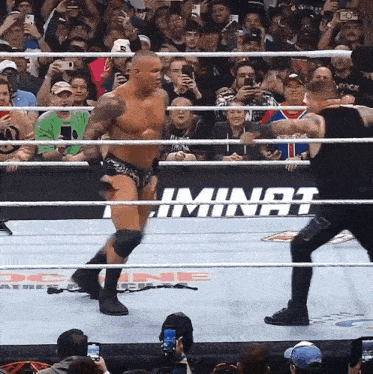 a wrestler in a ring with a sign that says ' iminat ' on it