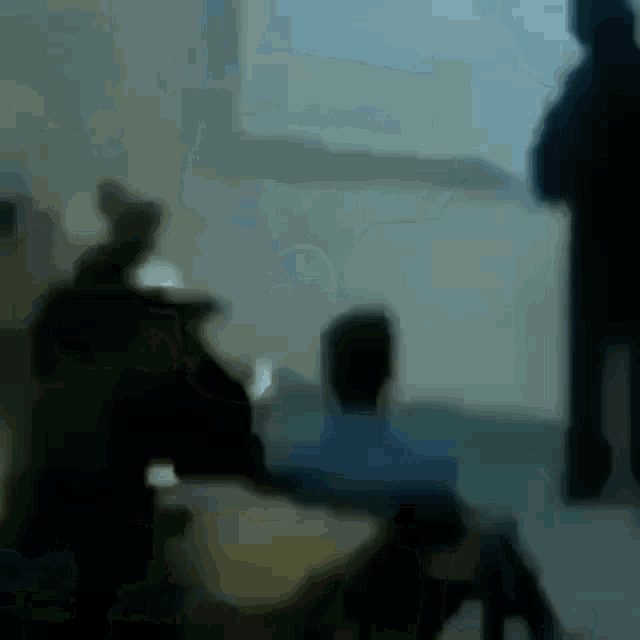 a blurry picture of people sitting in front of a window