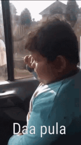 a person sitting in a car with the words daa pula on the bottom right