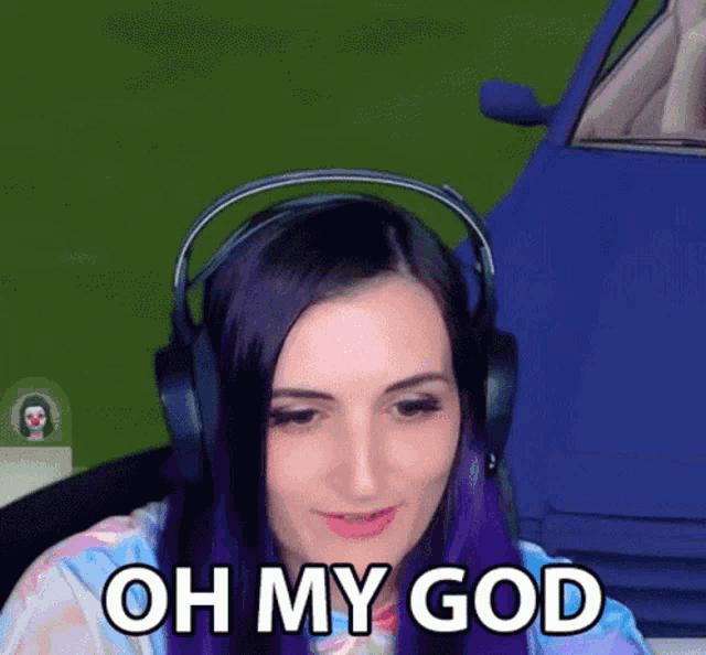 a woman wearing headphones says oh my god in front of a blue car