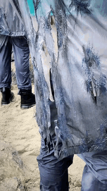 a person 's pants are covered in blue paint