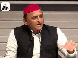 a man wearing a red hat and a black vest is sitting in front of a microphone .