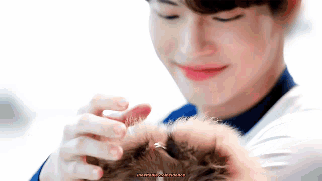 a close up of a person holding a small animal in their hands