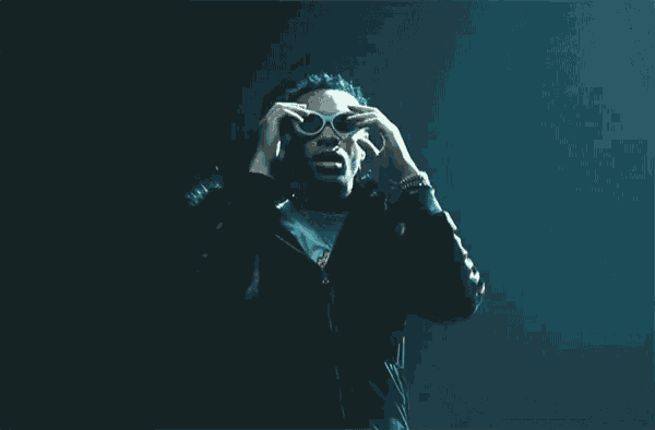 a man is holding a pair of glasses in his hands