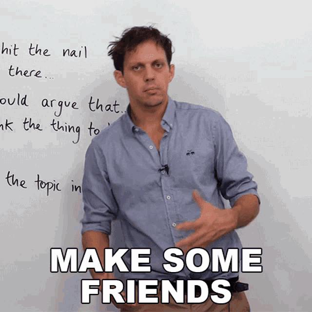 a man stands in front of a whiteboard with the words make some friends written on it