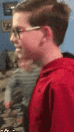 a boy wearing glasses and a red hoodie is smiling .