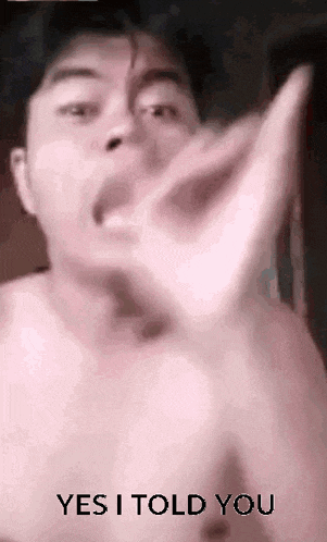 a man without a shirt is making a stop sign with his hands .