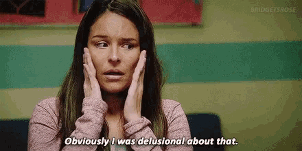a woman is holding her face and says obviously i was delusional about that .