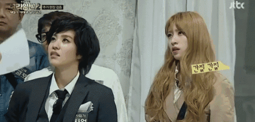 a woman in a suit and tie is sitting next to another woman in a suit and tie ..