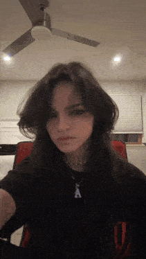 a girl wearing a necklace with a letter a on it