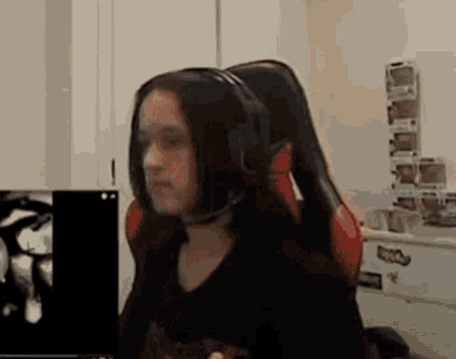 a woman wearing headphones is sitting in front of a computer .