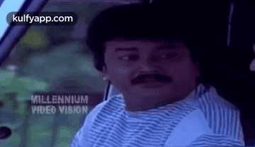 a man with a mustache is sitting in the back seat of a car .