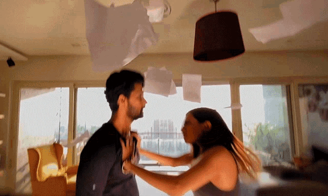 a man and a woman are fighting in a living room