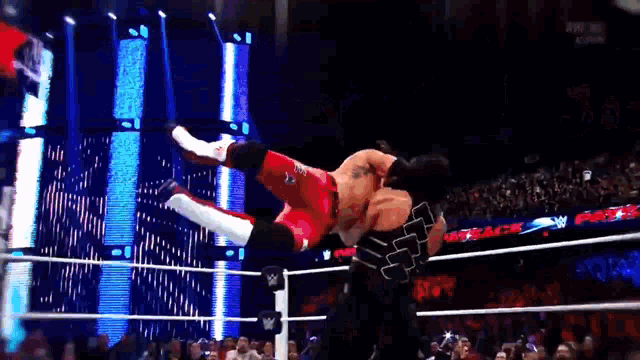 a man in a wrestling ring is jumping in the air
