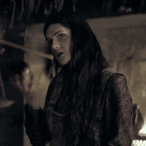 a woman with long black hair is covering her mouth with her hand