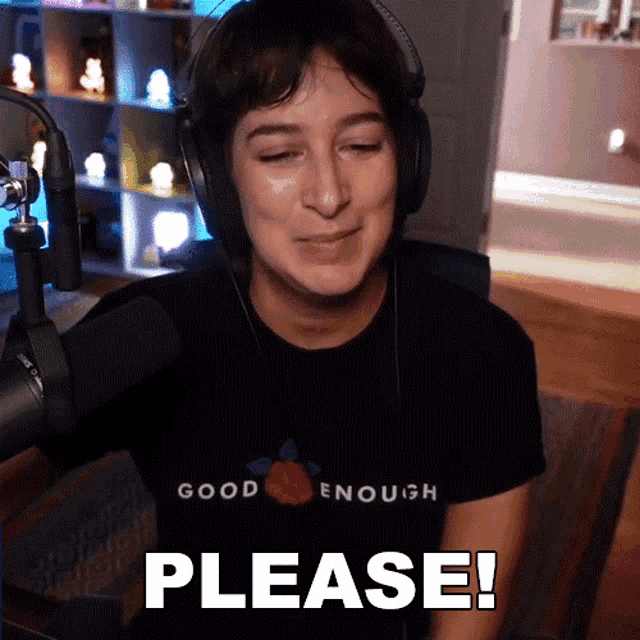 a woman wearing headphones and a shirt that says good enough