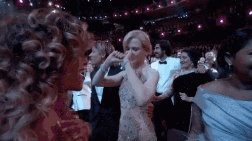 a woman in a white dress is dancing with another woman in a crowd of people .