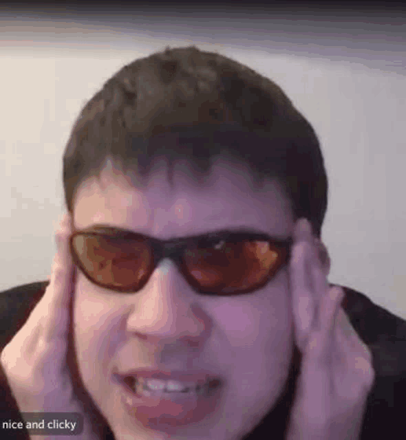 a man wearing sunglasses is making a funny face .