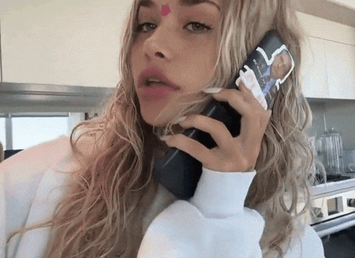 a woman is talking on a cell phone with a case that says ' a ' on it