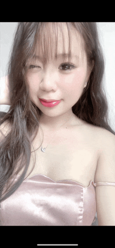 a woman wearing a pink dress and a heart shaped necklace