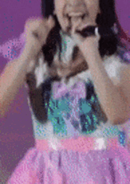 a girl in a pink and purple dress is holding a microphone in her hand .