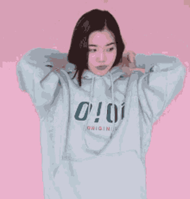 a girl wearing a hoodie with the number 0 on it is holding her hair .
