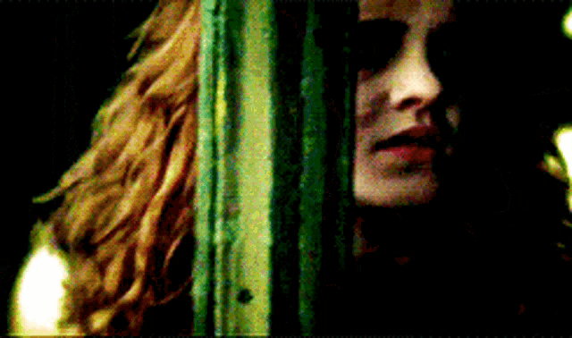 a close up of a woman 's face with a green background
