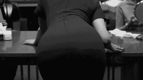 a woman in a black dress is kneeling down at a table .