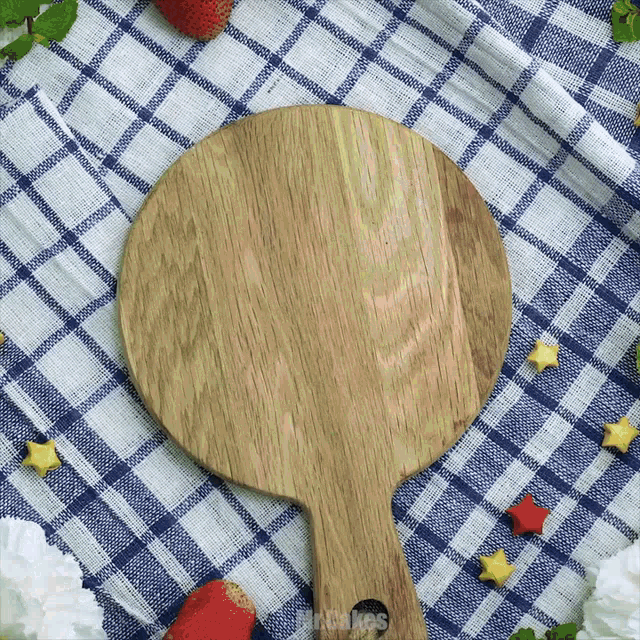 a wooden cutting board is on a blue and white checkered tablecloth