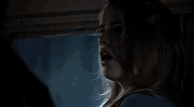 a close up of a man 's face looking at a woman in a dark room .