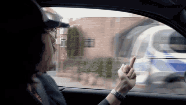 a person in a car giving a middle finger