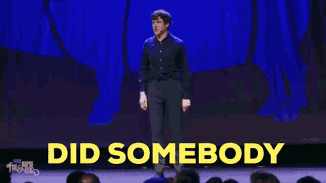 a man stands on a stage with the words mention cork above him