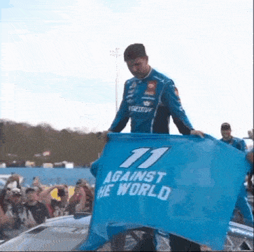 a man in a blue shirt is holding a blue flag that says against the world .
