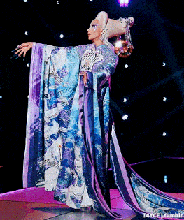a woman in a long blue and purple kimono holds a scale on her head